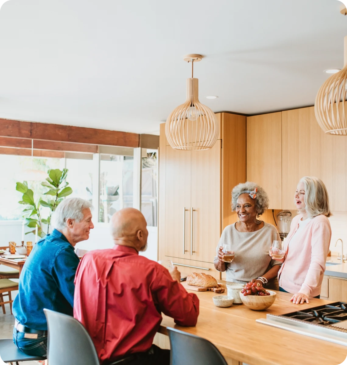 Seniors enjoying a meal and conversation in a cozy kitchen.