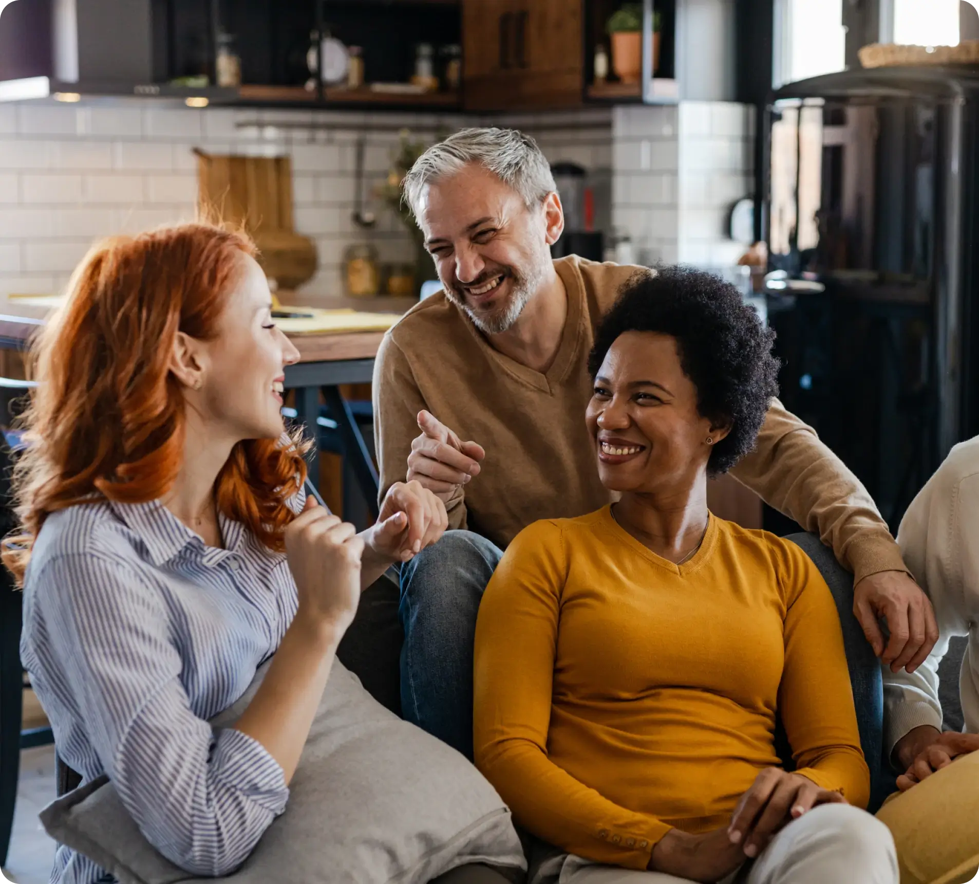 Three friends laughing and enjoying a casual moment at home.