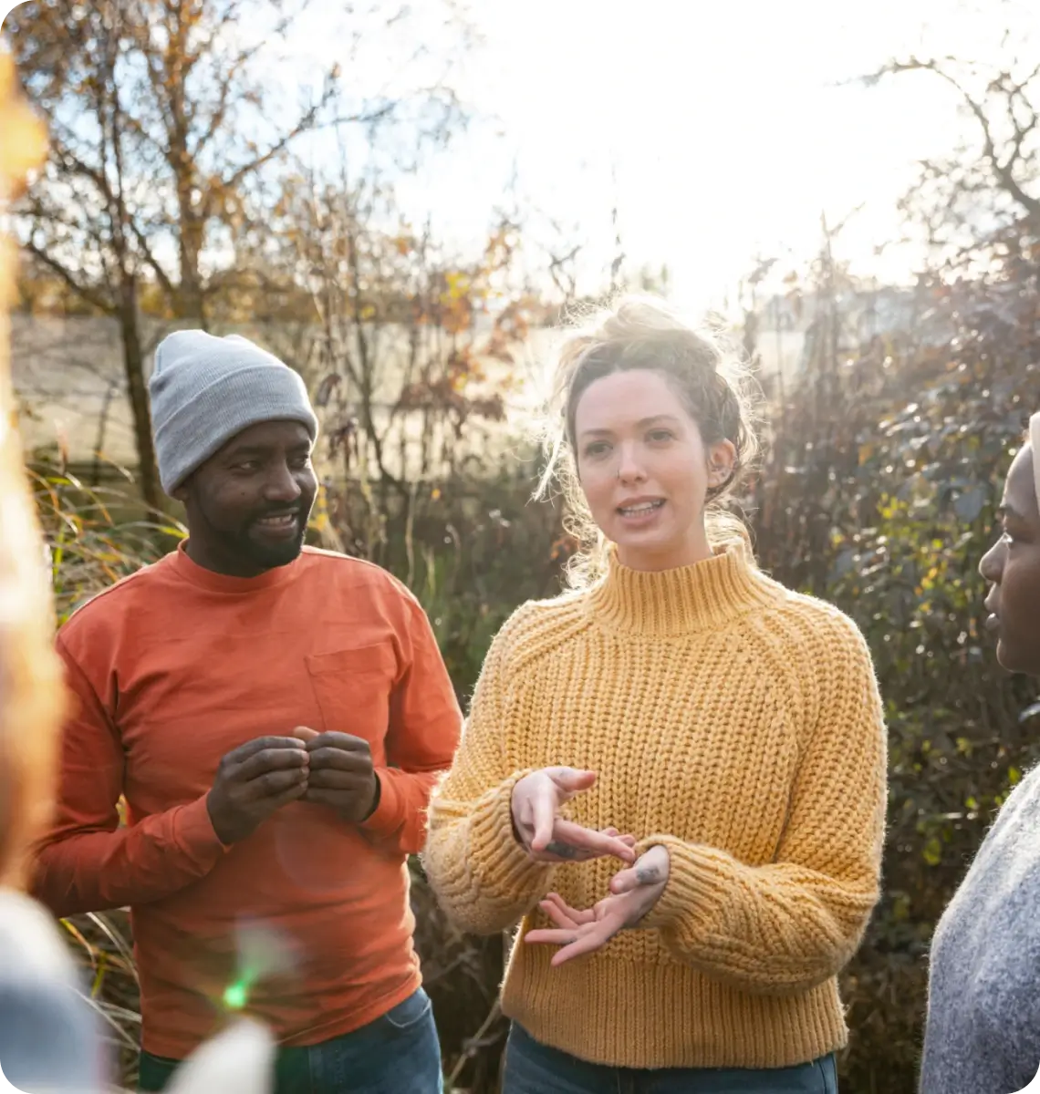 Group of people knitting outdoors on a sunny day.
